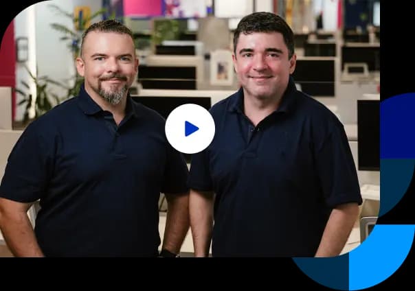 Os fundadores do Asaas, Piero Contezini e Diego Contezini, olhando e sorrindo para a câmera no escritório do Asaas.