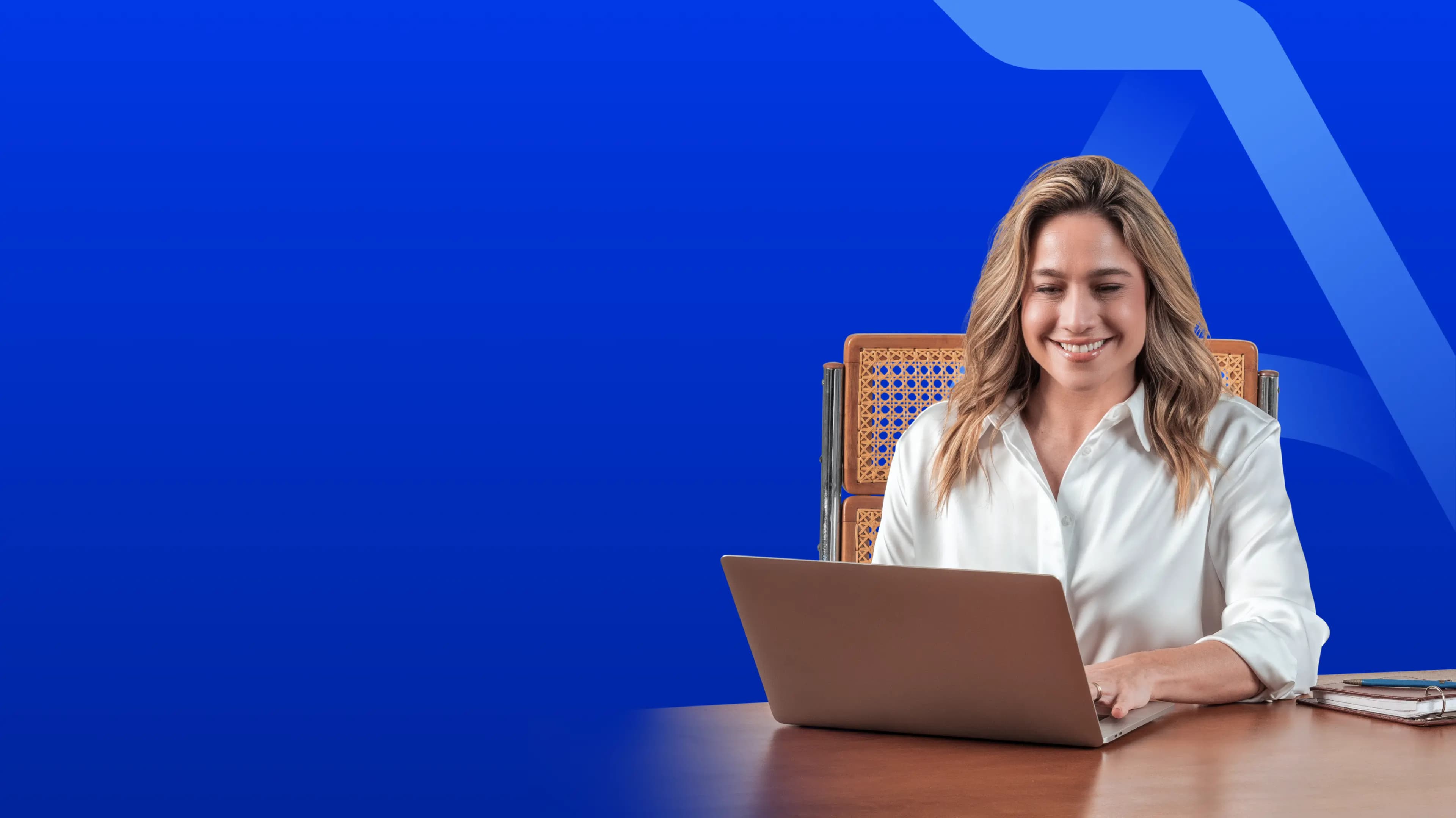 Fernanda Gentil sentada em uma mesa usando um notebook