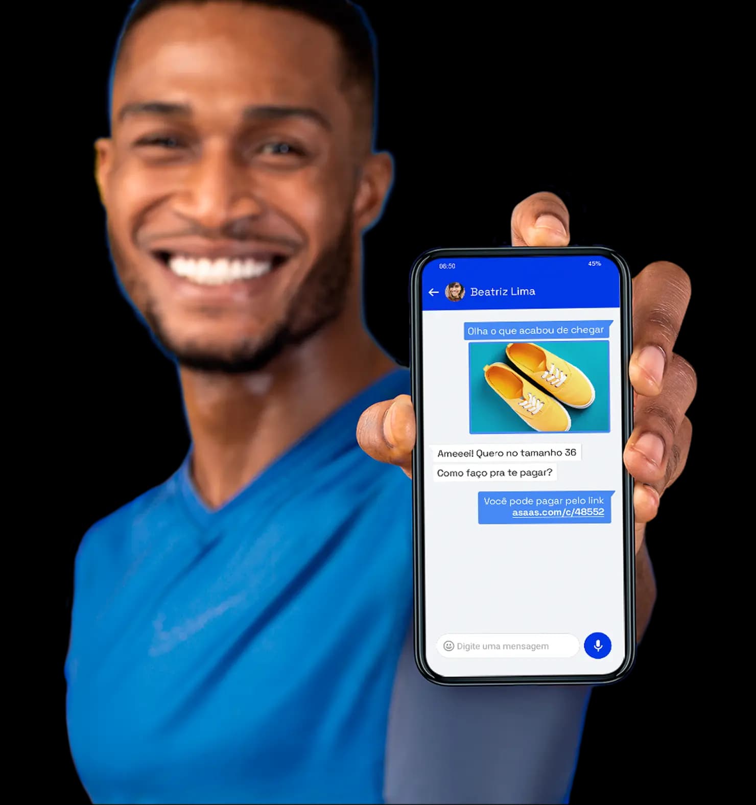 Homem sorri para a câmera enquanto segura um celular que mostra a tela de criação de link de pagamento.